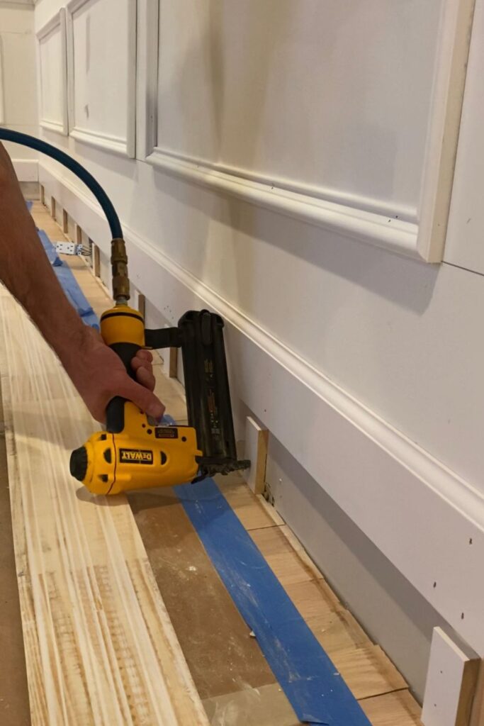 Carpenter installing custom wainscoting trim by hand inside an older Harrisburg, PA home