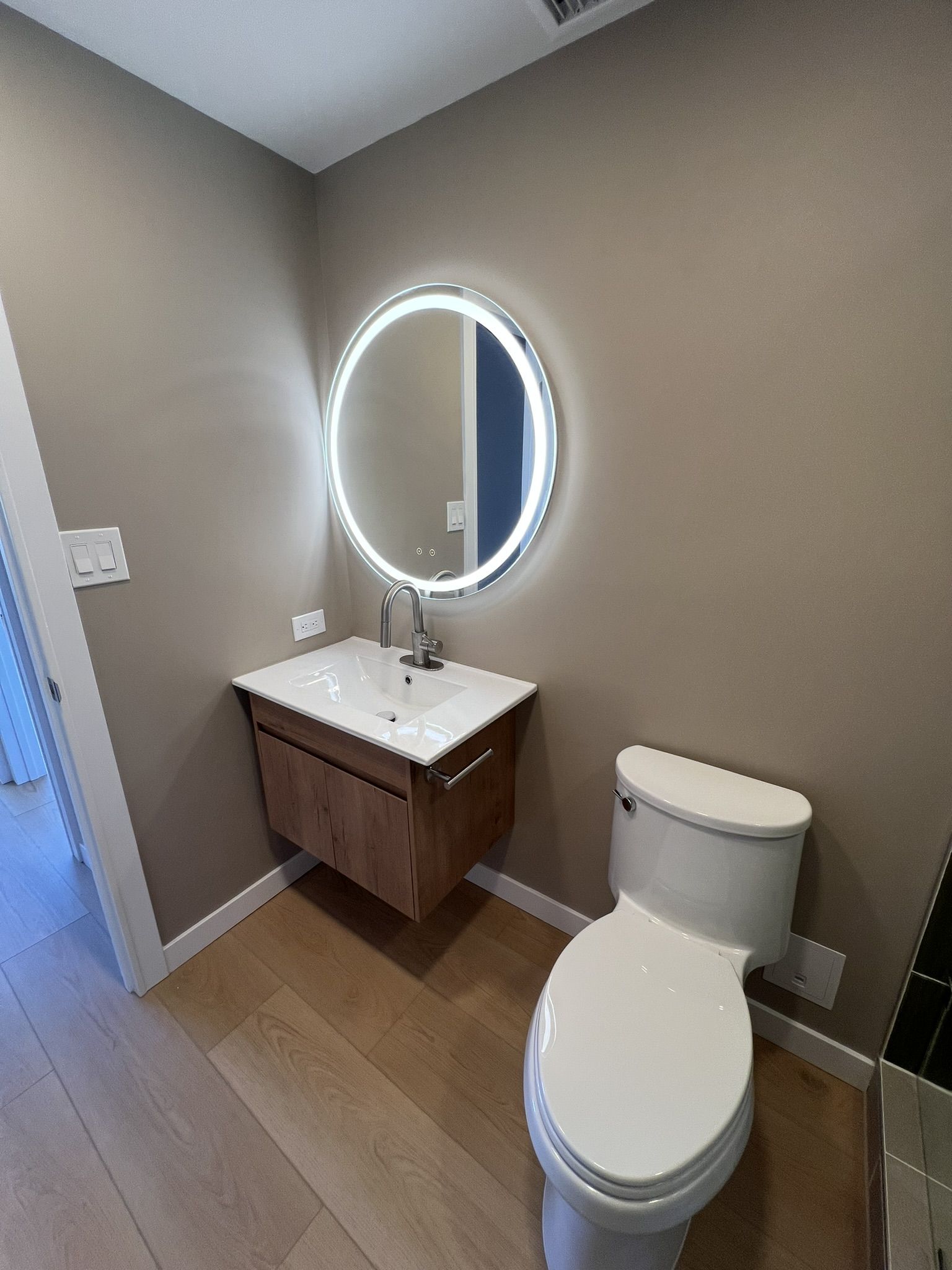 Renovated bathroom vanity and lighted mirror installed alongside a walk-in shower conversion in a Lebanon County PA home