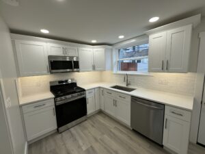 Finished white kitchen with gas range, quartz counters, and subway tile backsplash