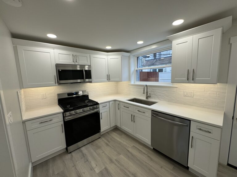Finished white kitchen with gas range, quartz counters, and subway tile backsplash