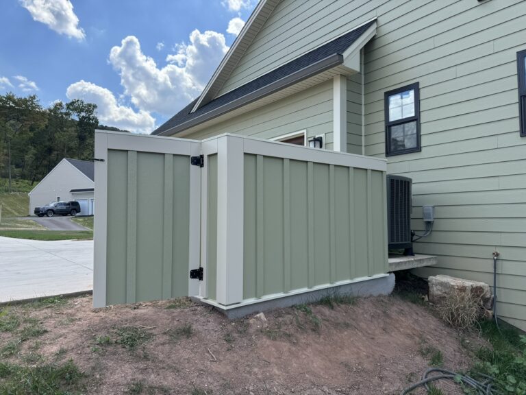 Painted equipment screen fence with gate beside a new construction home